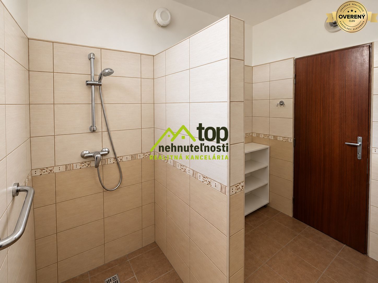 Kúpeľňa v rodinnom dome s moderným sprchovým kútom a úložným priestorom.