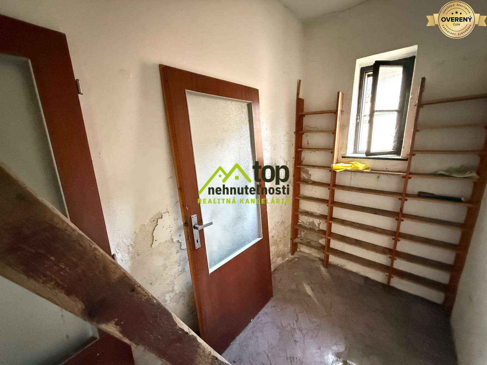 Stará miestnosť s poškodenými stenami a dverami v rodinnom dome.