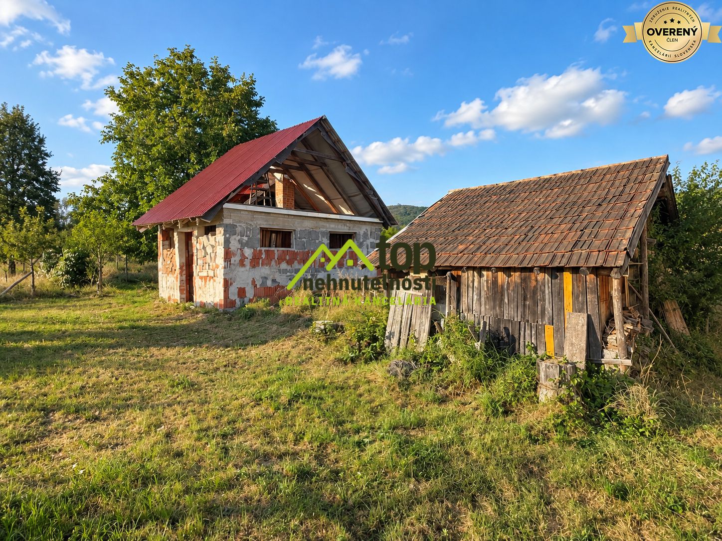 Kamenný rodinný dom vo Veľkom Klíži s drevenou kôlňou na slnečnom pozemku.