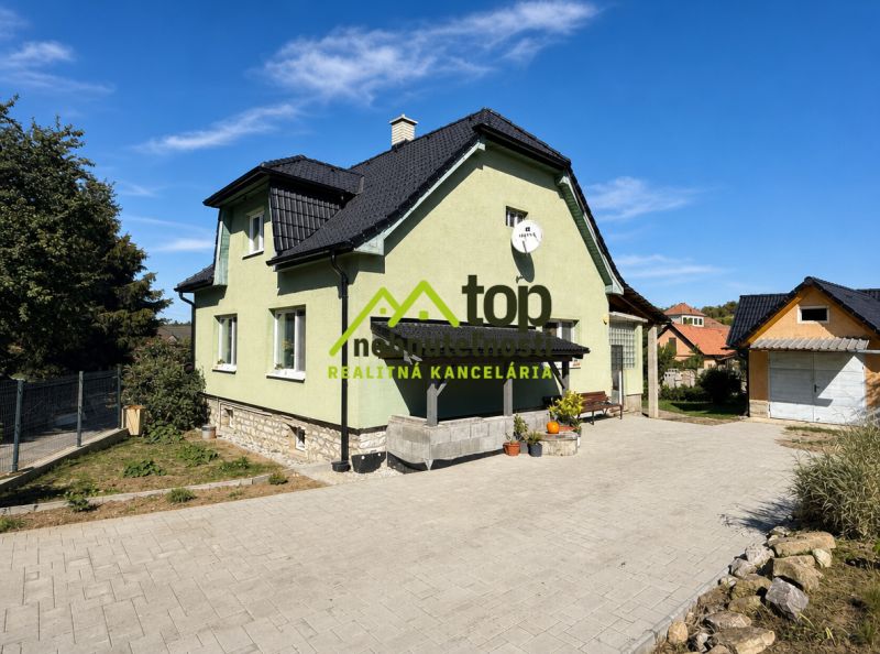 Rodinný dom v Krásne s obnovenou fasádou, záhradou a satelitnou parabolou.